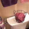 Poppy-colored bathroom linens stored in a pretty basket on the back of the toilet